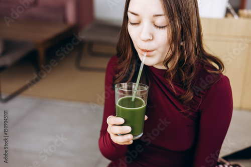 Female student enjoying a nutritious green smoothie photo