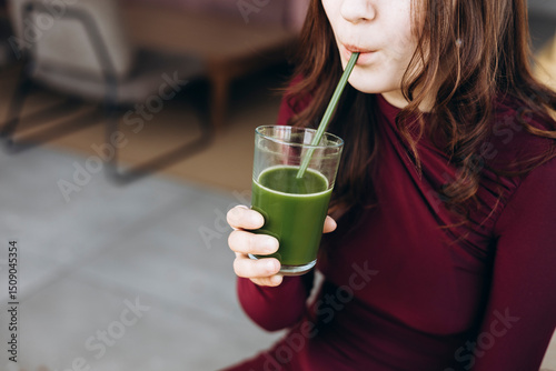 Female student enjoying healthy green smoothie