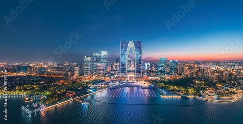 Fototapeta Naklejka Na Ścianę i Meble -  Striking aerial night view of a modern city skyline with distinctive architecture and illuminated waterfront in Suzhou, China. Urban business background.