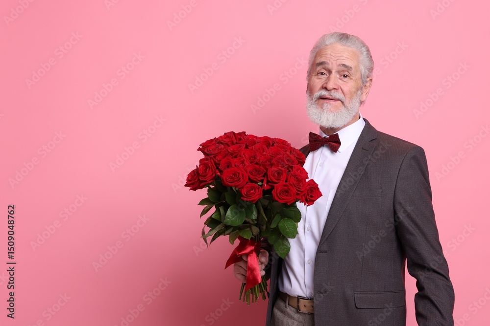 Senior man with bouquet of red roses on pink background, space for text Senior man with bouquet of red roses on pink background, space for text