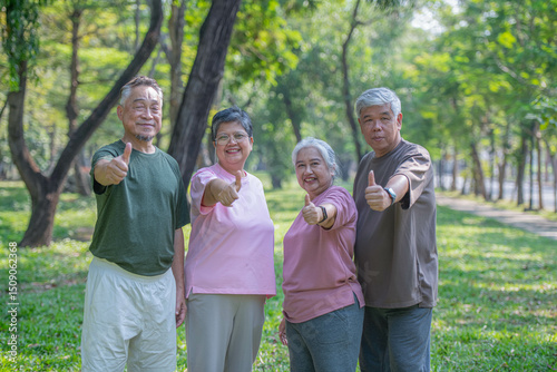 Four elderly men and women give a thumbs-up to show their satisfaction with the work they have done for the park.