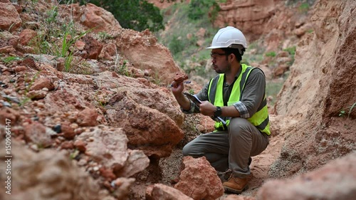 A geologist is examining the mineral content of soil and recording it on paper