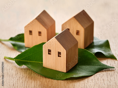 A symbolic image of a small wooden house placed on leaves, representing property market trends, housing demand, and the fragility of homeownership within changing economic landscapes photo