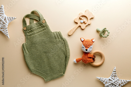 Knitted baby romper and accessories on neutral fabric background flatlay newborn outfit