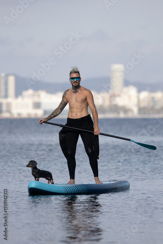 Photography Man paddle surfing with a dog.