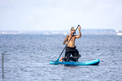 Canvas Print Man paddle surfing with a dog.