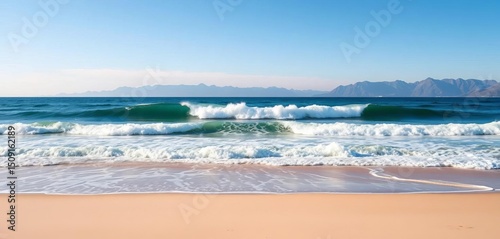 Fototapeta Naklejka Na Ścianę i Meble -  Distant mountains, ocean wave crashing on empty beach, copy space, landscape