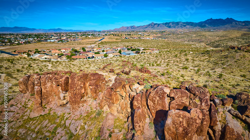 Aerial Desert Rock Formations and Suburban Neighborhood with Mountain Horizon