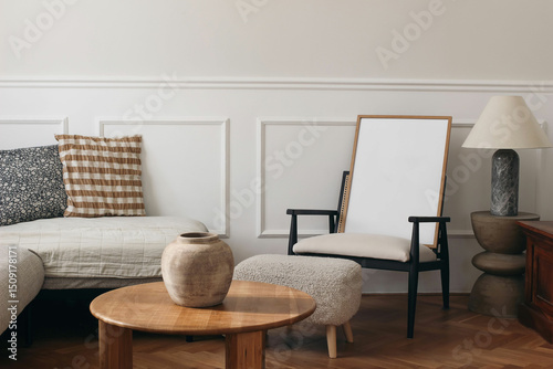Blank wooden picture frame mockup. Stylish living room interior. Minimalist furniture, neutral tones, and natural decor elements. Cozy seating area. Wooden table, ceramic vase. Marble lamp, lightning