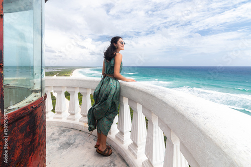 Slika na platnu Woman in green dress looking over the Caribbean Sea from Cozumel
