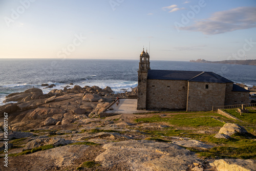 Sanctuary of A Virxe da Barca in Muxía, Galicia, Spain, perched on dramatic Atlantic cliffs. A key stop on the Camino de Santiago. Sunset.