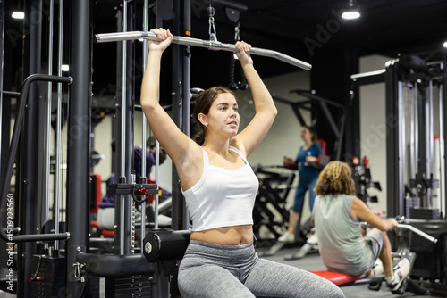 Wallpaper Mural Athletic young woman works out on simulator in gym Torontodigital.ca