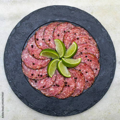 Portion of salami on black stone plate