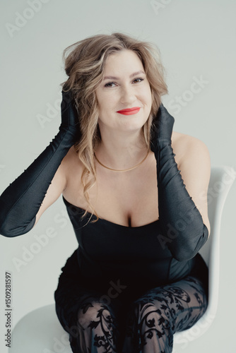 Portrait of beautiful young woman in black dress. long stylish gloves. girl luxury fashion model looks at camera. Pretty face evening makeup sexy eyes, an elegant hairstyle
