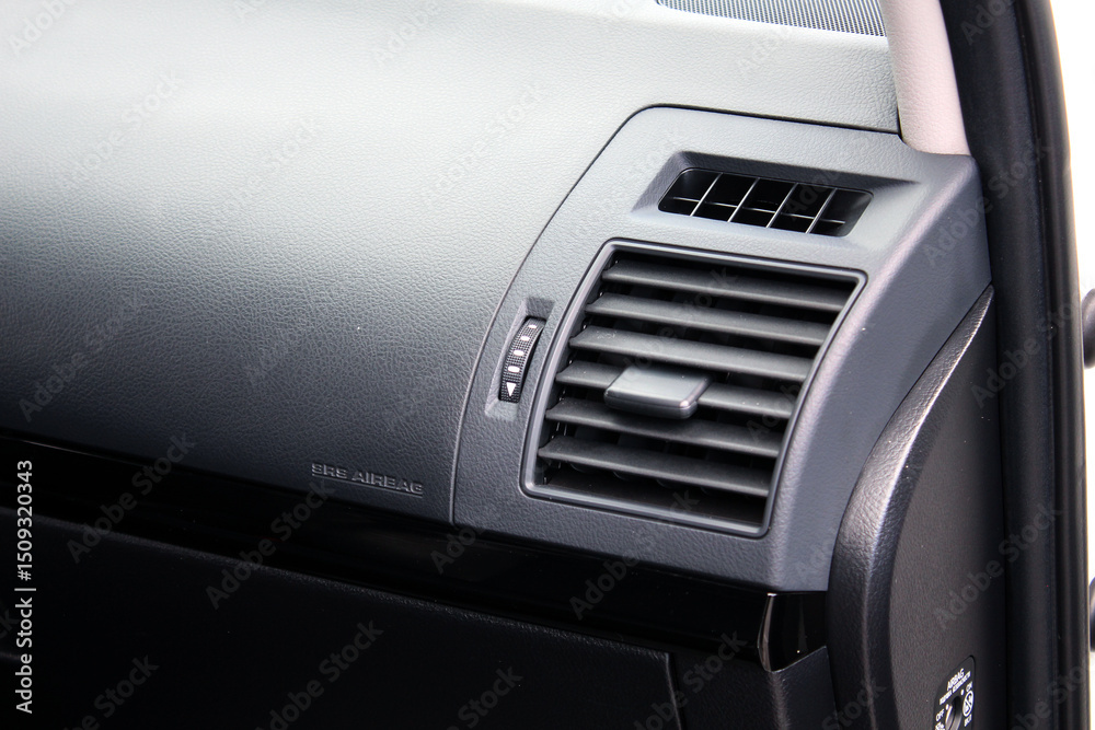 Car air conditioning. The air flow inside the car. Car ventilation close-up. Elements of a car air conditioning. Details of the front panel of SUV with air diffusers. Passenger airbag. Front airbag. Car air conditioning. The air flow inside the car. Car ventilation close-up. Elements of a car air conditioning. Details of the front panel of SUV with air diffusers. Passenger airbag. Front airbag.