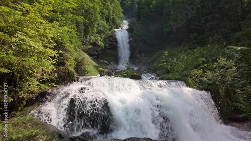Multi-tiered Giessbach Waterfalls cascade through dense green forest near Lake Brienz, Switzerland. 4K UHD video.