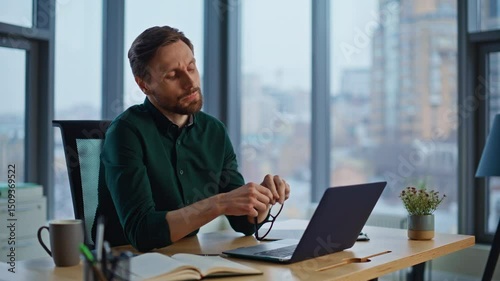 Pensive worker thinking issues looking laptop in office closeup. Serious man