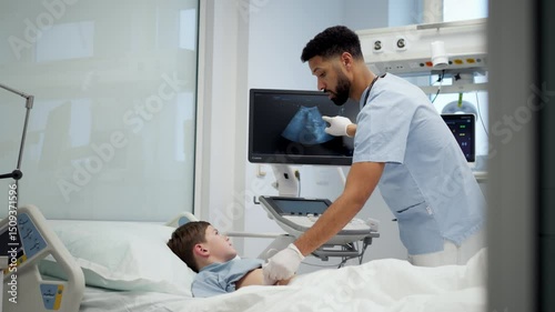 Doctor using ultrasound probe to check on young boy, abdominal ultrasound. photo