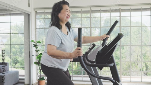 Asian senior woman exercising on elliptical trainer