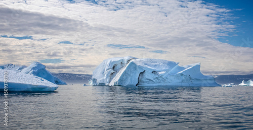 panorama of large  icebergs and dramatic sky in Disko Bay in Greenland photo