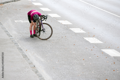 Bicyclist checks his broken bike on the road