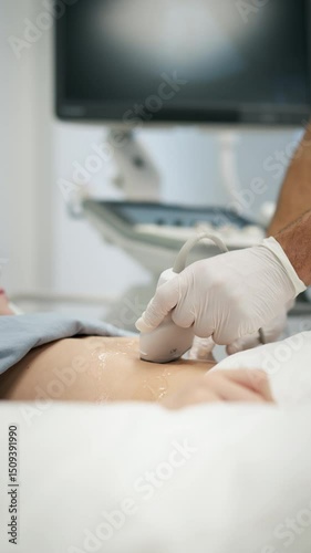 Doctor using ultrasound probe to check on young boy, abdominal ultrasound. photo