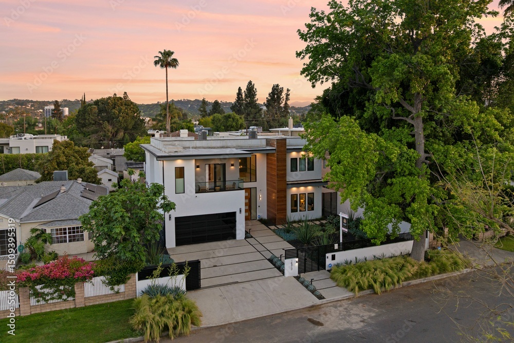 Fototapeta premium Modern luxury home exterior at sunset with pool, outdoor lounge, and contemporary architecture