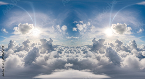 A panoramic view of a bright sky filled with fluffy white clouds and sunlight shining through the clouds