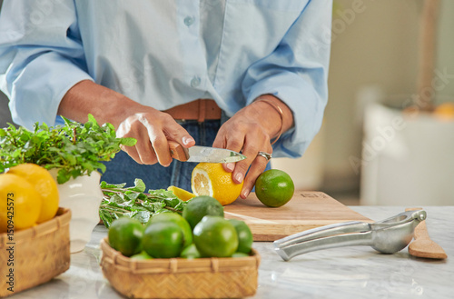 Manos de mujer con camisa azul cortando limones 