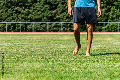 Wallpaper Mural Athlete walking barefoot on grass field after training session Torontodigital.ca