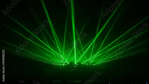 Green laser beams in a dark venue.