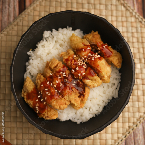 Rice bowl with chicken katsu and topped with sauce and sesame seeds