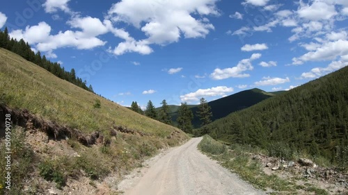 Driving on off-road car along a mountain forest road. Yazula mountain pass in Altai