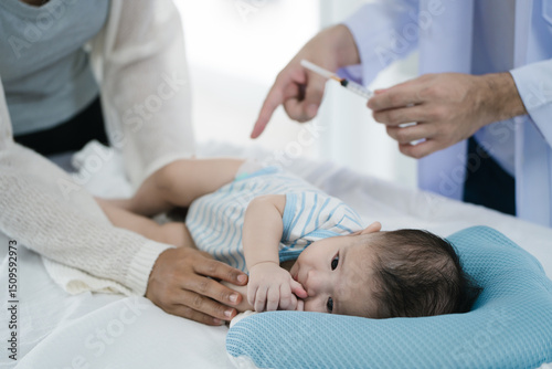 Asian loving mother comforts her three-month-old, as a male doctor administers essential childhood vaccinations, ensuring the baby's healthy future in a calm, professional setting.