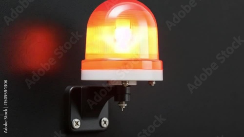 Close up view of a bright flashing red warning siren light mounted on a black wall Ai HD video.
