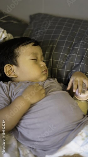 Toddler Is Sleeping While Holding His Bottle, Background for advertising and wallpaper in relaxion and lifestyle scene.