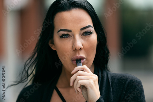 Adult Female Inhaling Vapor With An E-Cigarette