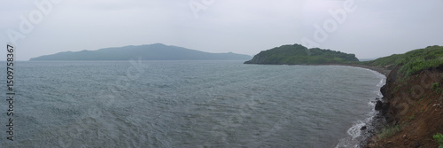 Looking down to crescent shape cove and seascape from the coast cliff