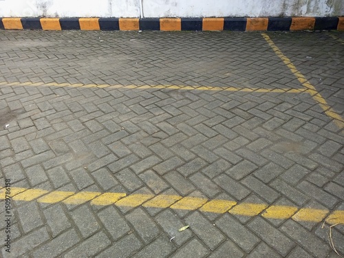 Empty Parking Area with Herringbone Pavers and Striped Curb