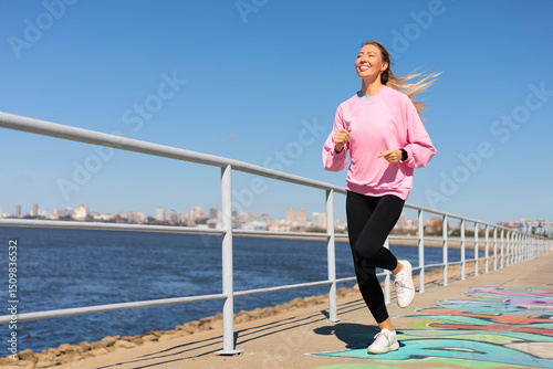 Woman jogging running on city embankment with graffiti enjoy outdoor sport activity