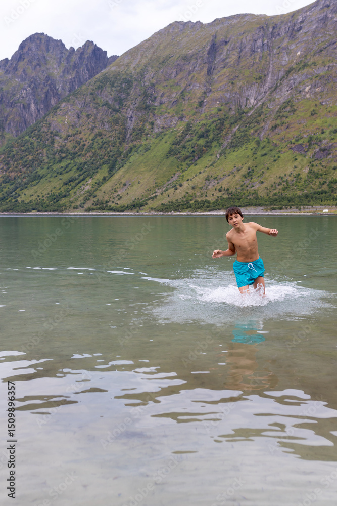 Children, swimming in Norwegian sea summertime, enjoying Norwegian nature Children, swimming in Norwegian sea summertime, enjoying Norwegian nature