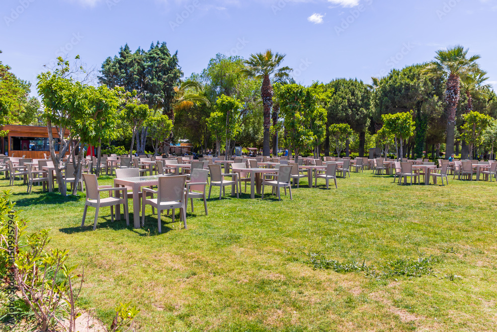 Aliaga, Turkey - May 28, 2025: tropical park with palm trees and green grass under a blue sky. Ideal for vacation, travel background, and relaxation themes. Aliaga, Turkey - May 28, 2025: tropical park with palm trees and green grass under a blue sky. Ideal for vacation, travel background, and relaxation themes.
