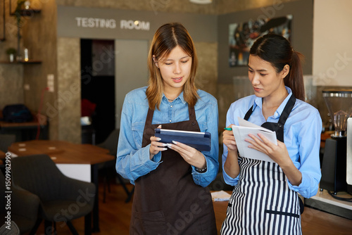 young baristas meeting and talking about work in the cafe