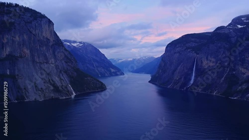 serene nordic fjord surrounded by dramatic mountain cliffs with twilight sky and cascading waterfall tranquil water reflecting evening light concept of travel destination, eco retreat, natural luxury