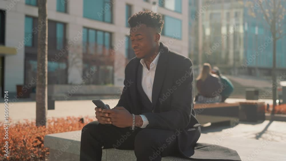 African american male person using smartphone in park in city center, portrait. Mobile gadget addiction of modern young people, overuse of internet and phones, modern technology for communication