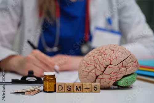 A dedicated medical professional writing detailed notes with DSM5, a brain model, and medication options
