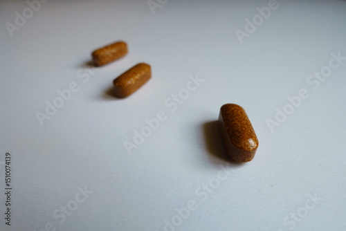 Close shot of three brown caplets of iron dietary supplement