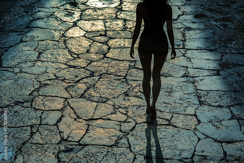 Woman walking on cracked pavement silhouette