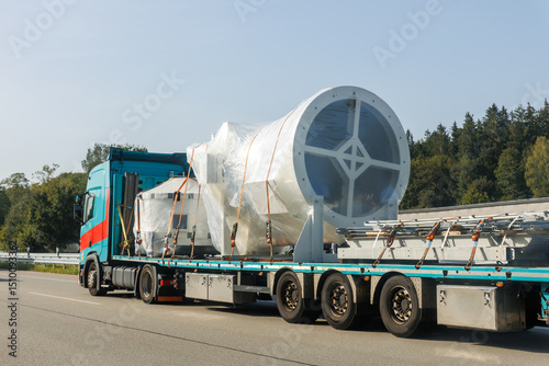 Wallpaper Mural Long heavy industrial truck semi trailer platform transport disassembled wind turbine component wrapped plastic common highway on bright summer day. Energy industry equipment transportation service Torontodigital.ca