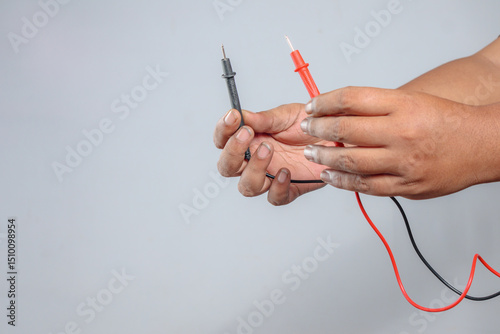 Multimeter probes in technician hands showing red black test leads for diagnostics